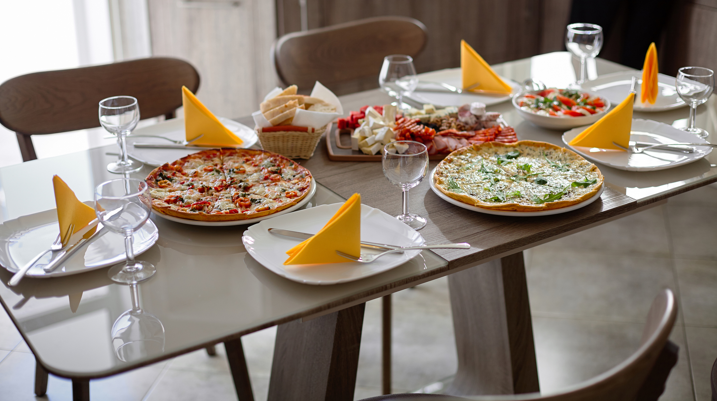 Dinner table served with silverware,glass stemware and delicious dishes